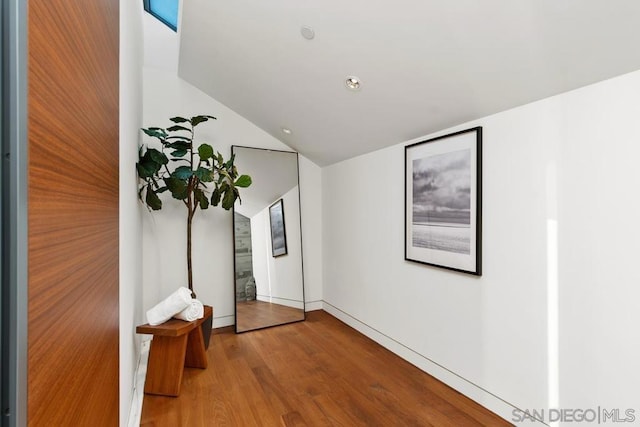 corridor featuring lofted ceiling and hardwood / wood-style floors