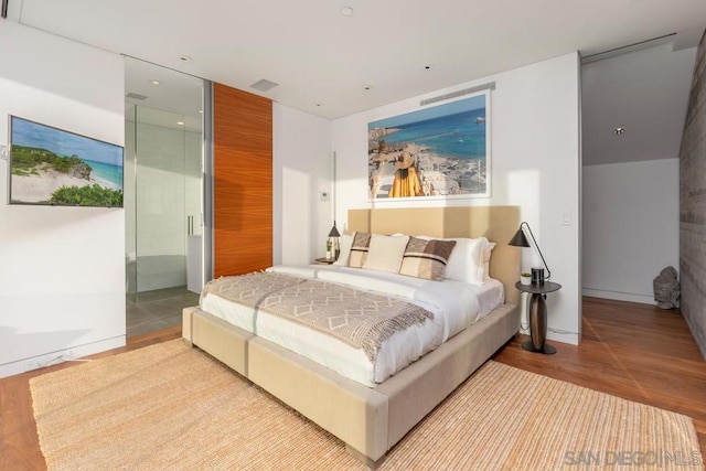 bedroom featuring ensuite bath and light hardwood / wood-style flooring