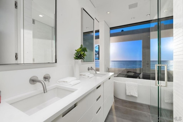 bathroom featuring vanity, independent shower and bath, concrete flooring, and a water view