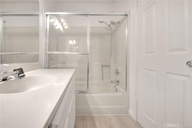 bathroom featuring vanity, bath / shower combo with glass door, and hardwood / wood-style flooring