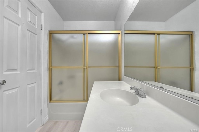 bathroom with vanity, combined bath / shower with glass door, and hardwood / wood-style floors