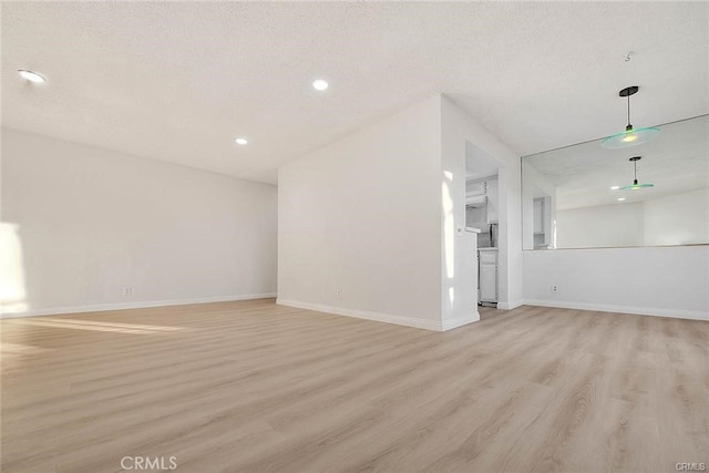 unfurnished living room with light hardwood / wood-style floors and a textured ceiling