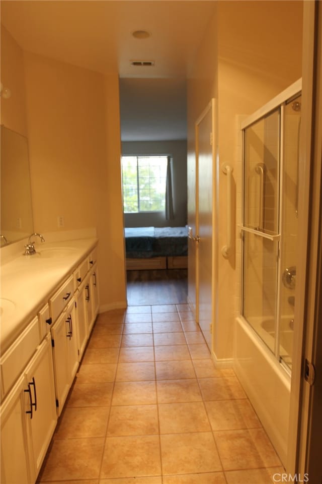 bathroom with tile patterned flooring, vanity, and shower / bath combination with glass door