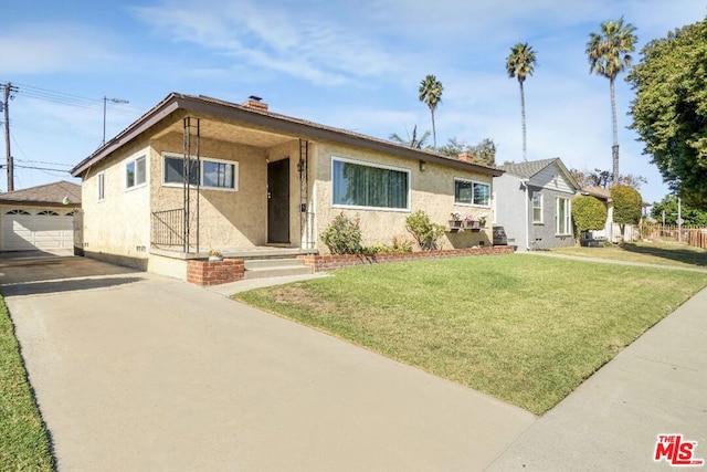 view of front of property with a garage, an outbuilding, and a front yard