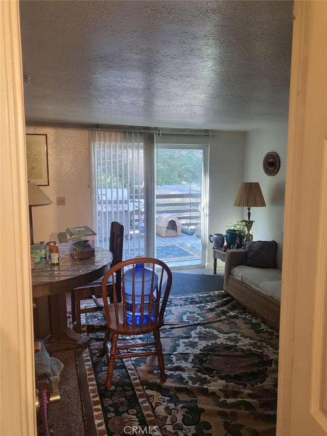 dining space with carpet and a textured ceiling