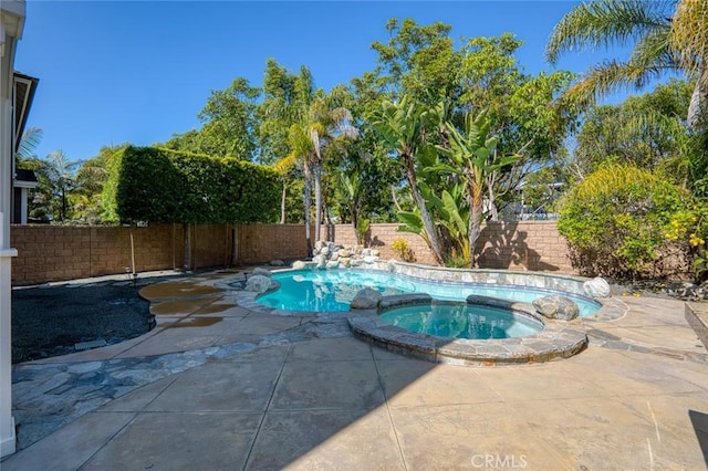 view of swimming pool featuring a patio area, a fenced backyard, and a pool with connected hot tub