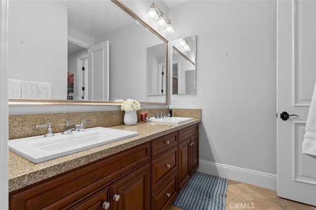 full bath featuring a sink, baseboards, and double vanity