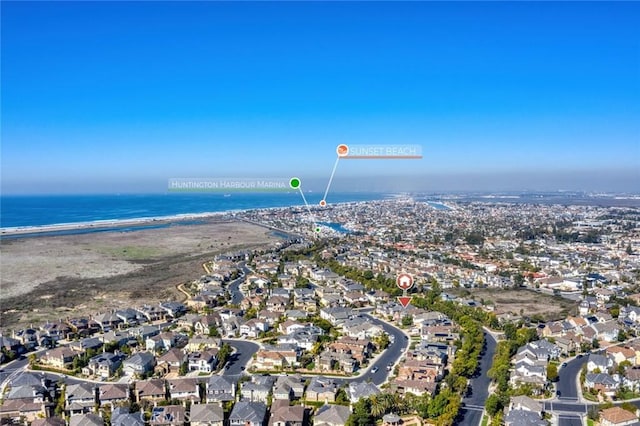 drone / aerial view with a residential view, a water view, and a beach view