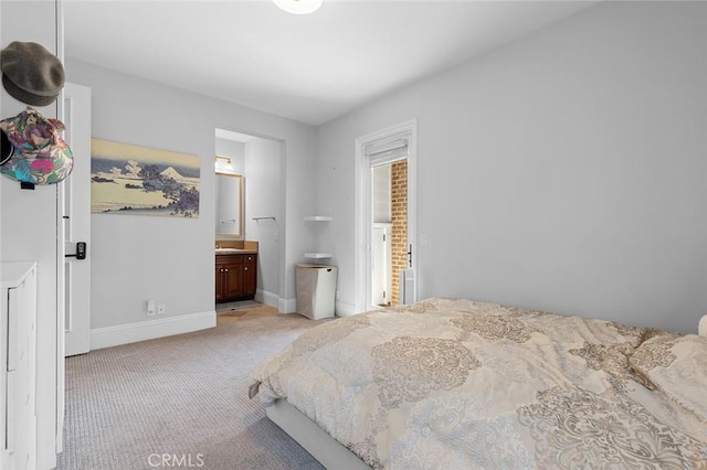 bedroom featuring baseboards, connected bathroom, and light colored carpet
