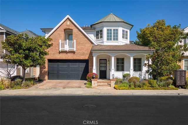 view of front of house featuring an attached garage, a balcony, covered porch, brick siding, and concrete driveway