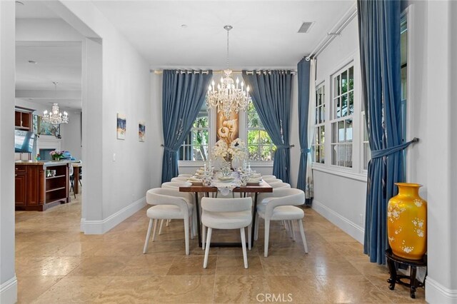 dining area featuring a chandelier, visible vents, and baseboards