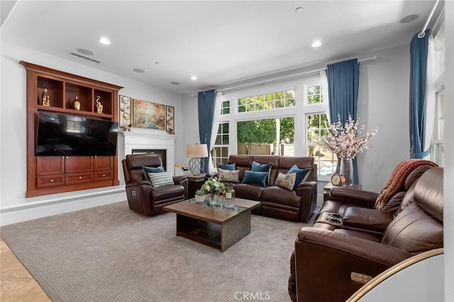 carpeted living area with recessed lighting, visible vents, and a fireplace