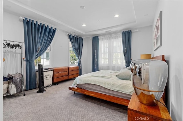 bedroom with carpet, a raised ceiling, and recessed lighting