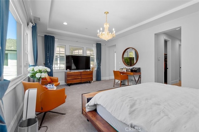 bedroom with a tray ceiling, multiple windows, carpet, and an inviting chandelier