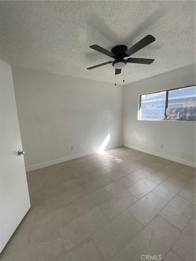 tiled spare room with ceiling fan and a textured ceiling