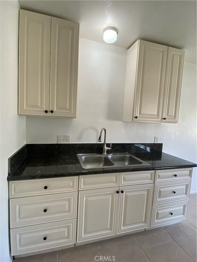 kitchen with white cabinetry, sink, and light tile patterned flooring