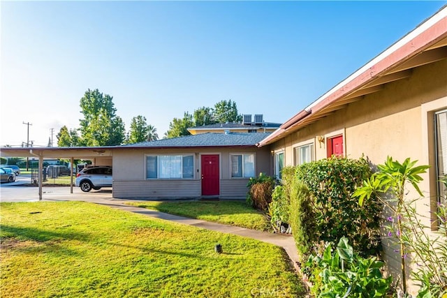 view of front of house featuring a front lawn and a carport