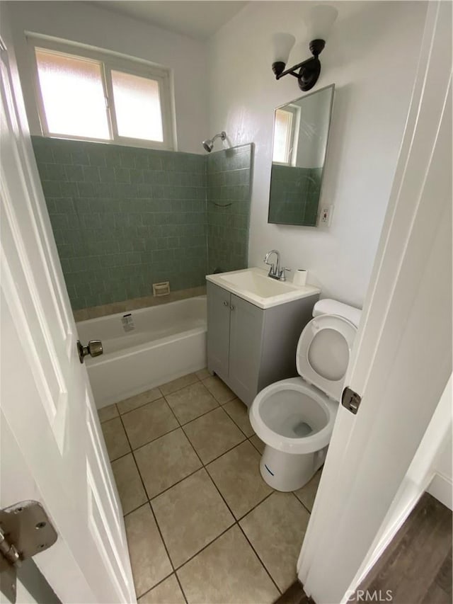 full bathroom featuring tile patterned floors, tiled shower / bath combo, toilet, and vanity