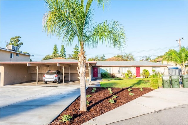 ranch-style house featuring a carport, a front yard, and central AC