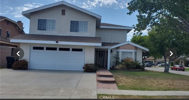 view of front property featuring a garage and a front yard