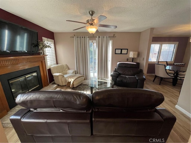 living room featuring a wealth of natural light, light hardwood / wood-style flooring, and a textured ceiling