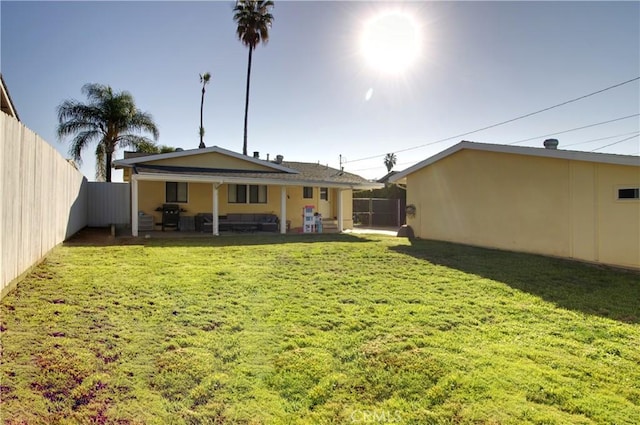 back of house with a patio and a lawn