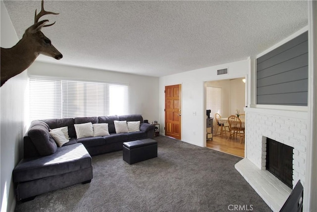 carpeted living room with a textured ceiling and a fireplace