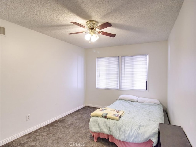 carpeted bedroom with ceiling fan and a textured ceiling