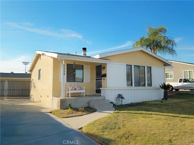 view of front of property with covered porch and a front lawn