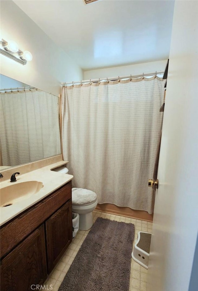 full bathroom with vanity, shower / tub combo, and toilet