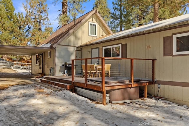 rear view of house featuring a deck and a covered hot tub