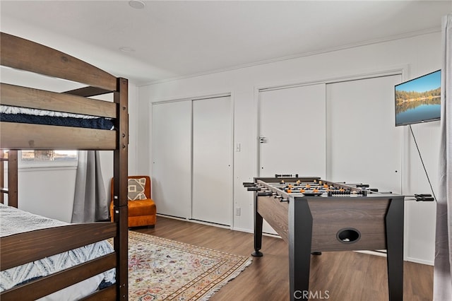 bedroom with multiple closets and hardwood / wood-style floors