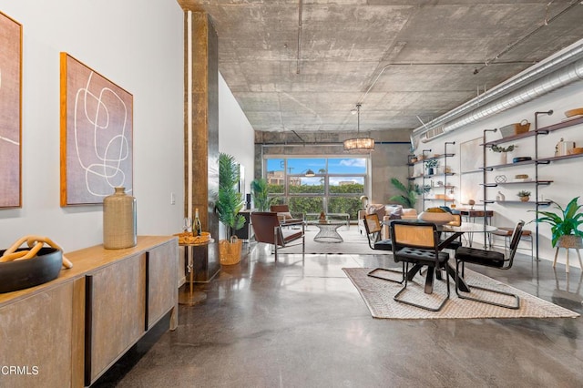 dining space with a chandelier and concrete flooring