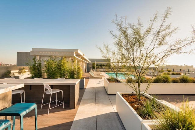 surrounding community with a patio area, a pool, and an outdoor bar