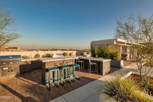 view of patio / terrace with exterior kitchen, a bar, and area for grilling