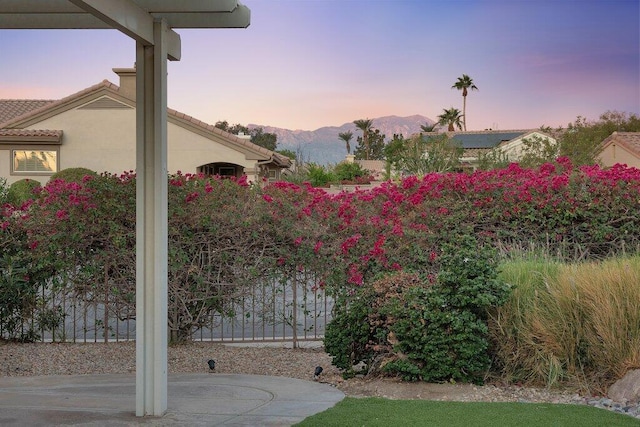 yard at dusk featuring a mountain view