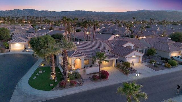 aerial view at dusk featuring a mountain view