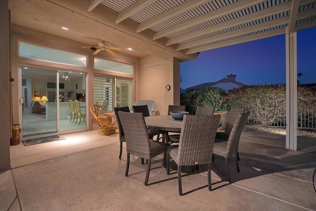 patio terrace at dusk featuring ceiling fan and a pergola