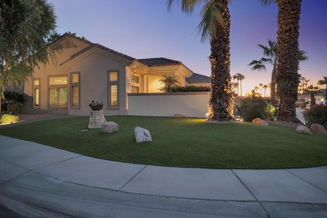 mediterranean / spanish home featuring a yard