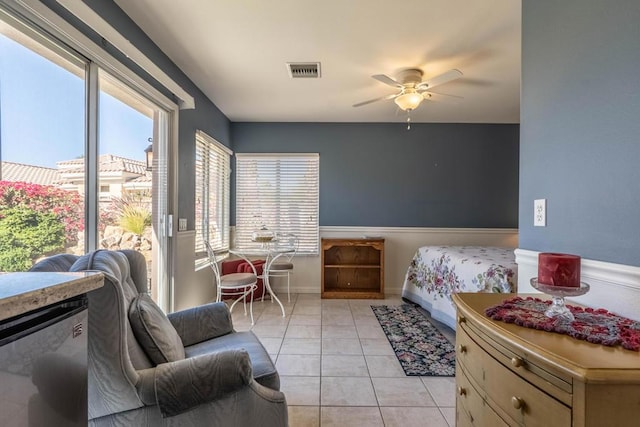 tiled bedroom featuring ceiling fan and multiple windows