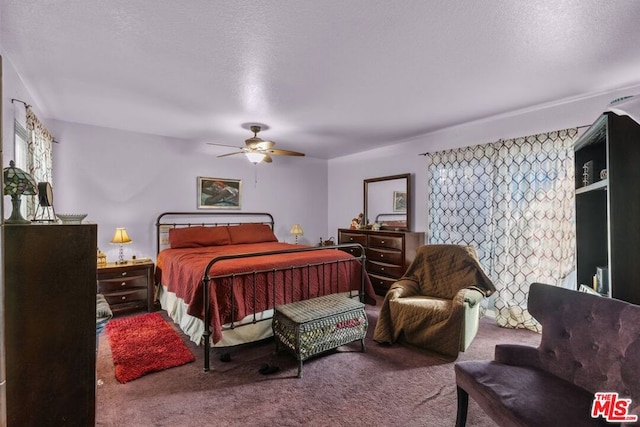 carpeted bedroom with ceiling fan and a textured ceiling