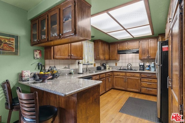 kitchen with kitchen peninsula, sink, and tasteful backsplash