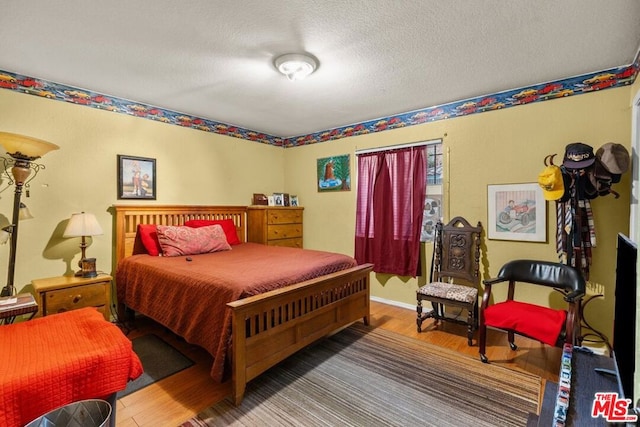 bedroom featuring a textured ceiling and hardwood / wood-style flooring