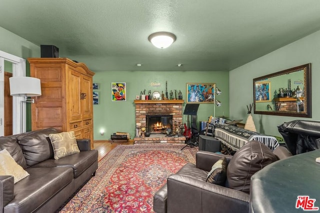 living room featuring a fireplace, a textured ceiling, and hardwood / wood-style flooring