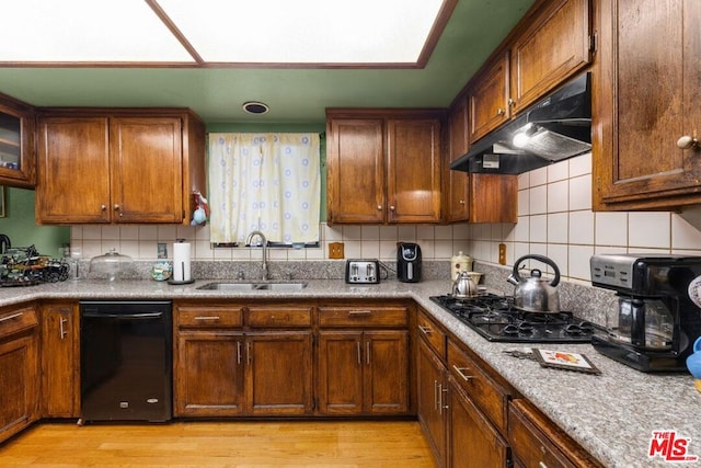 kitchen featuring sink, light hardwood / wood-style floors, tasteful backsplash, and black appliances