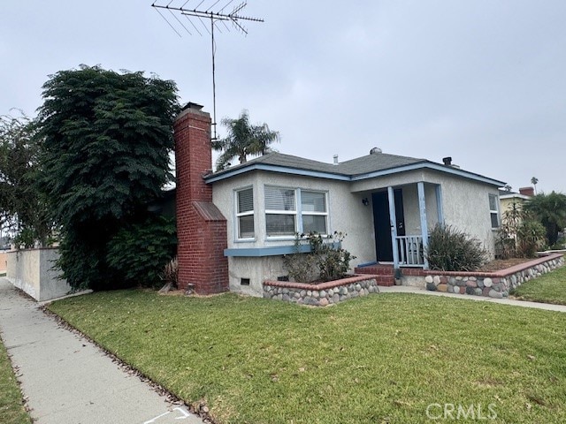 view of front of house with covered porch and a front yard