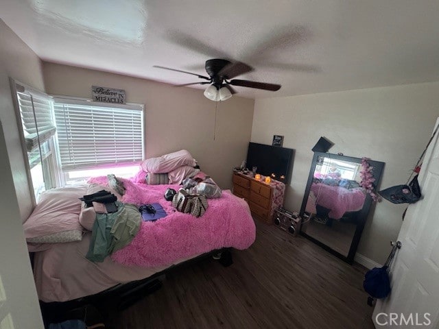 bedroom with dark hardwood / wood-style flooring and ceiling fan