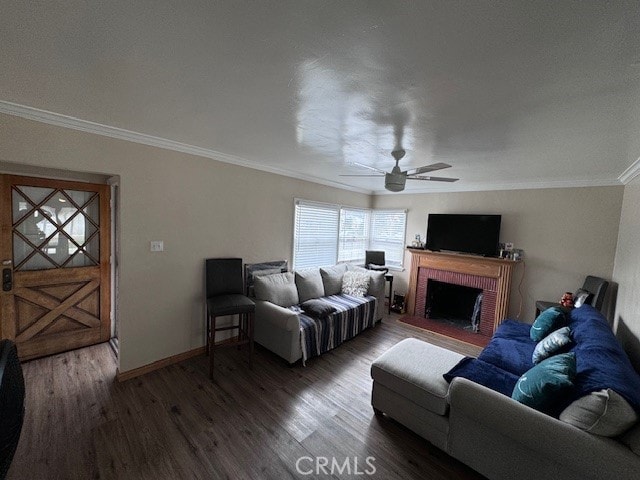 living room with crown molding, a brick fireplace, dark hardwood / wood-style floors, and ceiling fan