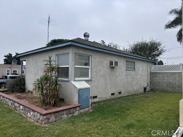 rear view of property with a wall unit AC and a lawn