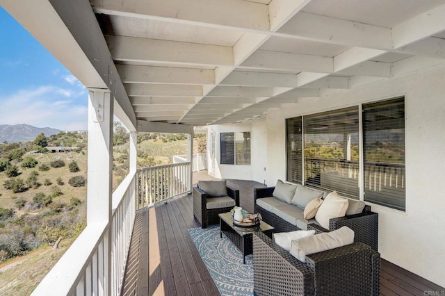 wooden terrace featuring a mountain view and an outdoor living space